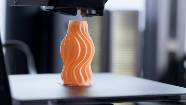3D Printer, 3D Printing orange object. 4.0 industrial revolution. Extreme Close Up.