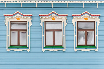 Frozen windows with carved wooden architraves. Facade of typical merchant tatar house.