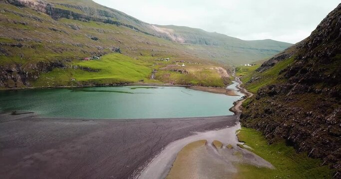 Slow drone shot  of a salt water pond near Saksun, small, isolated village surrounded by mountains on Faroe islands
