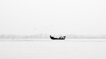 Naklejka premium Monochrome of fishing boat in sea against clear sky