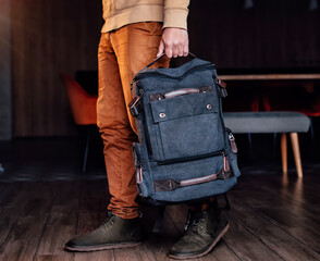 man holding in hand canvas backpack