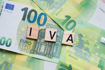 the inscription IVA or VAT in Italy next to euro banknotes. Concept showing value added tax