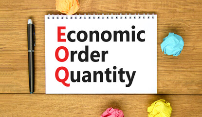 EOQ economic order quantity symbol. Concept words EOQ economic order quantity on white note on beautiful wooden table wooden background. Pen. Business EOQ economic order quantity concept. Copy space.