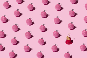 Decorative Christmas baubles and red bell on a pink background. New year creative pattern.