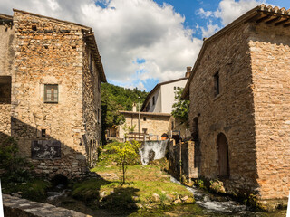 Fototapeta na wymiar rustic stone houses flank one of the many water channels in the characteristic village of Rasiglia, a charming village in umbria, italy
