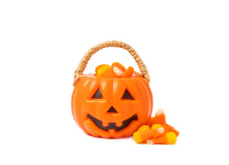 Corn candy in isolated on white background.Halloween concept. Bucket of Halloween pumpkin Jack-o-lantern with candy corn for halloween celebration.Pumpkin with a scary smile on his face.Candy bucket.