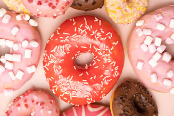 Donuts with red and pink glaze, top view. Lots of donuts, sweet and delicious food