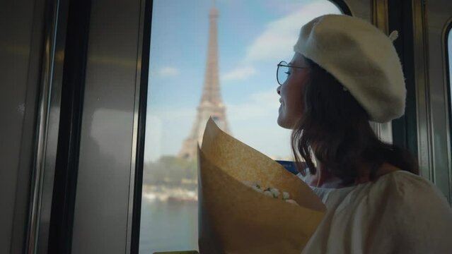 Young girl with a bouquet riding in the subway past the Eiffel Tower in Paris