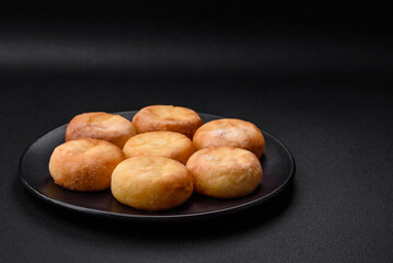 Delicious fresh cottage cheesecakes with raisins and vanilla on a black ceramic plate