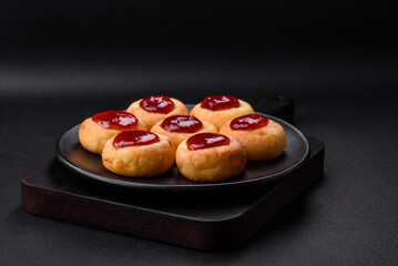 Delicious fresh cottage cheesecakes with raisins and vanilla on a black ceramic plate