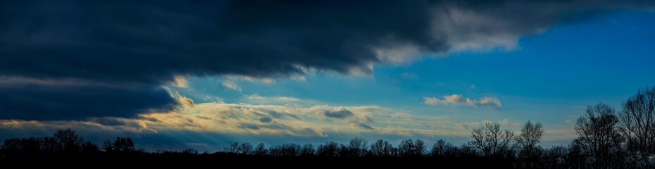 Obraz na płótnie Canvas Forest, dark clouds at sunset.