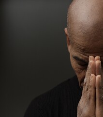 man praying to god with hands together Caribbean man praying with black background stock photos stock photo