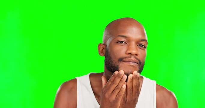 Beard, grooming and face of a black man on a green screen isolated on a studio background. Looking, beauty and portrait of an African guy applying a product to facial hair for growth with mockup