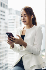 Woman standing and using mobile and social media. Woman playing on her Smart phone