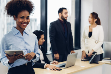 Obraz premium Call center business woman talking on headset. Call center worker accompanied by her team. Customer service executive working at office.