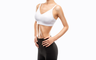 A slender, young, athletic woman in black leggings on a light background. Healthy lifestyle, sport and diet.