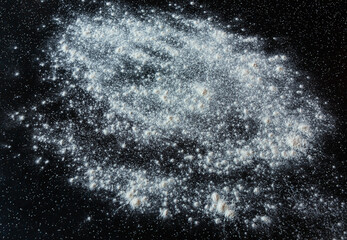 Flour is scattered on the surface of a black table - preparation for cooking