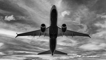 Close-up on an airplane taking off seen from below. Suggestive black and white image of a passenger...