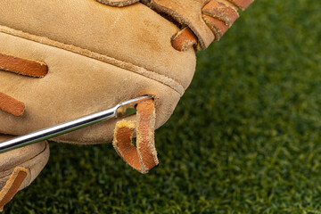 Repairing baseball glove laces with lacing needle. Glove relacing, sports equipment repair and...