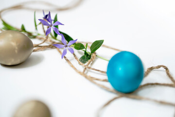 Easter eggs, twine and periwinkle on a white background. easter spring flowers. spring. greeting.