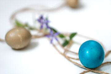 Easter eggs, twine and periwinkle on a white background. easter spring flowers. spring. greeting.