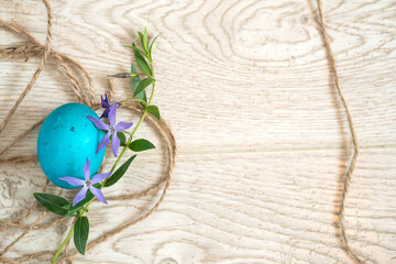 Easter egg, twine and periwinkle on a wooden surface. easter spring flowers. spring. greeting.