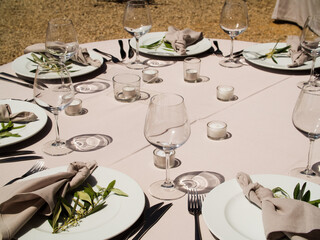 Wedding banquet concept. Chairs and round table for guests, served with cutler and, flowers and crockery and covered with a tablecloth