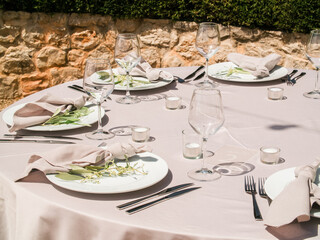 Table at luxury wedding reception event. Beautiful flowers on table and serving dishes and glasses and decoration