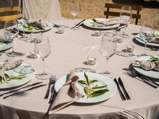 Table at luxury wedding reception event. Beautiful flowers on table and serving dishes and glasses and decoration