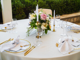 Table at luxury wedding reception event. Beautiful flowers on table and serving dishes and glasses and decoration
