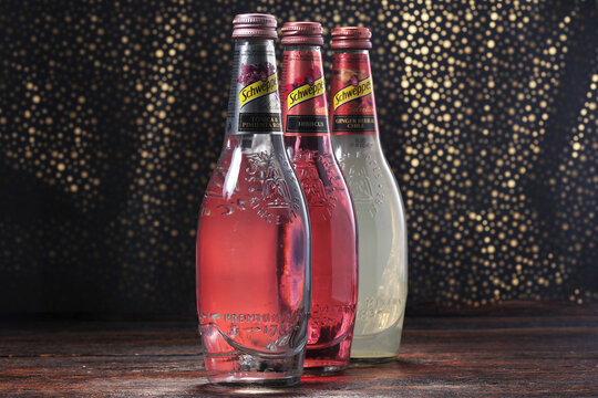 Koszalin, Poland, March 25, 2023. Schweppes Glass bottle on an abstract background. Schweppes logo. Photo of bottles with different flavors of Schweppes