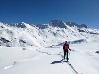 Fototapeta na wymiar Ski touring track through the deep snow in a beautiful lonely mountain landscape. Sentisch Horn. Skitouring, Skitour, Ski Tour, Skimo, Davos Klosters Switzerland. High quality photo