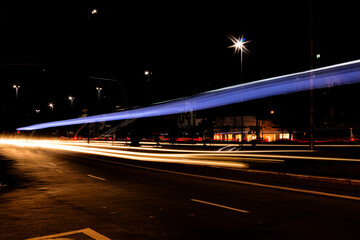 Rastro de luz do farol e lanternas dos carros que trafegam durante a noite nas avenidas da cidade...