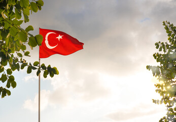 The flag of Turkey is developing in the blue sky.