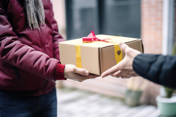 A man's hand gives an empty recycled paper cardboard box shopping for a woman. Delivery box mockup for branding design concept. generative AI