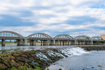 Landscape of the bridge over the river. River flowing with rocks under the road bridge on a blue cloudy sky background. Samsun, Turkey