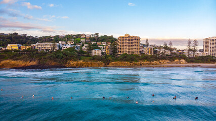 Obraz premium Aerial, drone view of the spectacular Sunshine Coast city near Brisbane. Beautiful buildings on the cliffs and golden sand beaches at sunrise. Landscape of Queensland, Australia