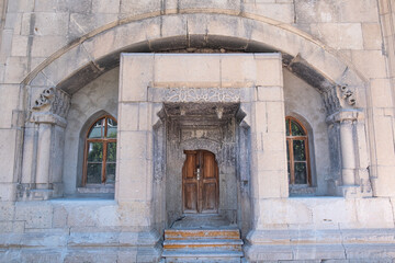 Fototapeta na wymiar A building with decorative historical old stones and old carved wooden door. Museum of Amasya, Turkey