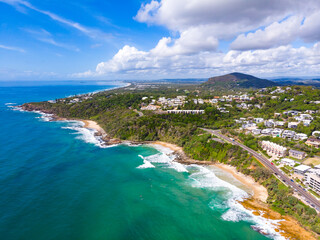 Aerial, drone view of the spectacular Sunshine Coast city near Brisbane. Beautiful buildings on the cliffs and golden sand beaches at sunrise. Landscape of Queensland, Australia