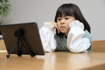 タブレットで動画を見る女子小学生 (8歳)