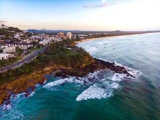 Aerial, drone view of the spectacular Sunshine Coast city near Brisbane. Beautiful buildings on the cliffs and golden sand beaches at sunrise. Landscape of Queensland, Australia