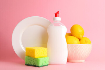 Dishwashing detergent and lemons on a colored background