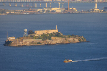 Alcatraz Island and sightseeing ferry in San Francisco Bay at Golden Hour