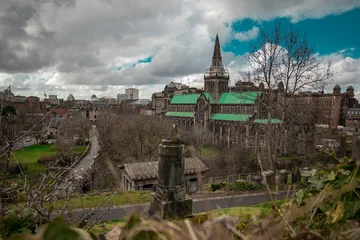 Fotobehang Big Glasgow cathedral on a spring day looking from above at the location of Glasgow Necropolis. Cloudy day and a big victorian cathedral church © Anze