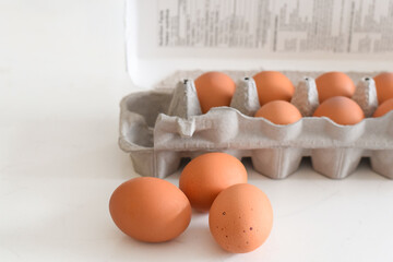 Fresh brown eggs in carton on kitchen countertop