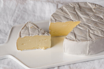 Brie cheese on white serving board