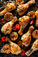 Spicy roasted chicken legs, drumsticks seasoned with garlic, hot peppers and aromatic herbs on a...