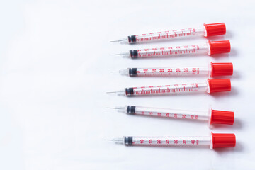 Red plastic syringes on a white background with copy space. top view