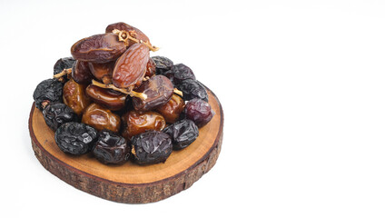 Various of dried dates or kurma on wooden sliced. isolated on white background