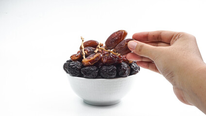 several dates, one of which is a hand picked, isolated on white background